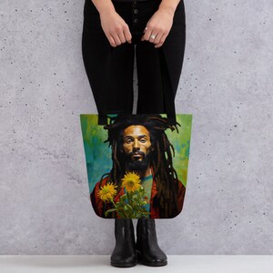 May include: A tote bag featuring a colorful portrait of a man with long dreadlocks holding sunflowers. The background is a vibrant green and blue.