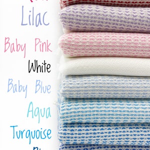May include: A stack of eight folded woven textiles in various colors including red, lilac, baby pink, white, baby blue, aqua, turquoise, and blue. Each textile features a consistent textured weave pattern and is labeled with its color name.