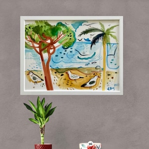 May include: A watercolor painting of a beach scene with palm trees, seagulls, and waves. The painting is framed in a white frame and has the artist's signature and the year 2022 in the bottom right corner.