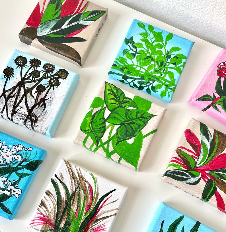 May include: A collection of eight small, square canvases with painted floral and plant designs. The canvases are painted in various shades of green, blue, red, and white. The designs include a variety of flowers, leaves, and branches.