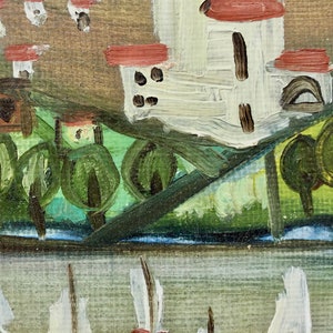 May include: A painting of a village scene with white houses with red roofs, green trees, and a blue river in the foreground.