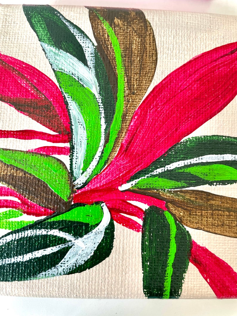 May include: A painting of a stylized flower with green, white, brown, and pink leaves on a beige canvas.