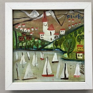 May include: A framed painting of a village with a church in the center, surrounded by green trees and white sailboats on a body of water. The painting is signed "H.B" and titled "Fl&uuml;elen".