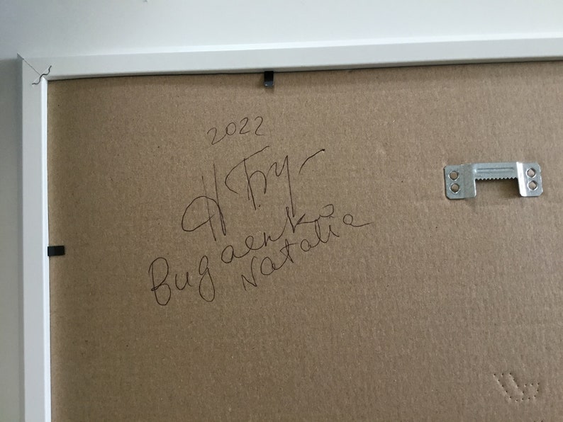 May include: A brown cardboard backing with a white frame. The backing has handwritten text that says "2022", "A.Try", "Bug aenko", and "Natalie".