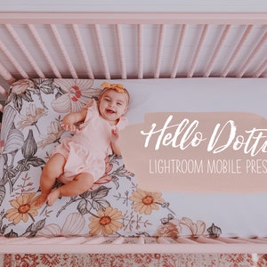 Puede incluir: Una niña pequeña con un vestido rosa y una diadema amarilla yace en una cuna rosa con una sábana estampada con flores. El texto "Hello Dottie Lightroom Mobile Preset" está escrito en blanco sobre un fondo melocotón.