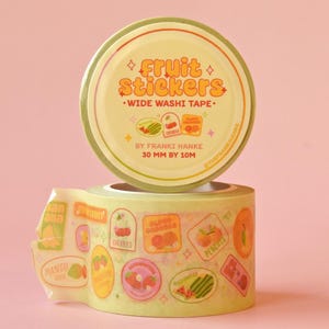 Two rolls of washi tape stacked on a pink backdrop. The washi tape is a wide 30mm width featuring artwork of fruit stickers. The tape's label reads "Fruit Stickers Wide Washi Tape By Franki Hanke 30mm by 10M."