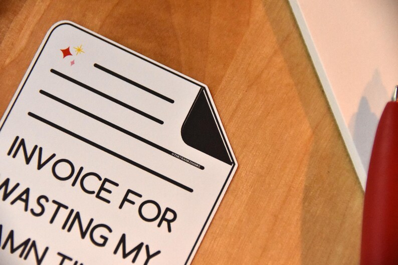 Op de afbeelding: Een witte factuur met zwarte tekst met de tekst "INVOICE FOR WASTING MY DAMN TIME". De factuur heeft zwarte lijnen en een decoratieve hoek. Een rode pen is zichtbaar op de achtergrond.