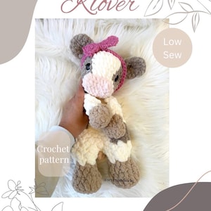 May include: A handmade crochet cow plushie with a pink bow, white, brown, and cream colors. The text "Klover" is at the top, and "Crochet pattern" is on the left. The words "Low Sew" are on the right.