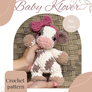 May include: A plush crochet cow toy featuring white and brown patches, a pink snout, and a pink bow on its head. The image includes text that reads Baby Klover, No Sew, and Crochet pattern, with the handle @sevenandsway visible on the toy.