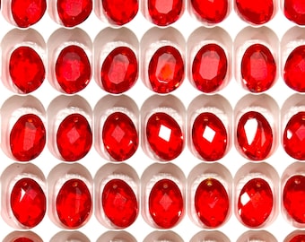 Puede incluir: Una vista cercana de una hoja de piedras de cristal rojas de forma ovalada. Las piedras de cristal están dispuestas en un patrón de cuadrícula y todas son del mismo tamaño. Las piedras de cristal son brillantes y reflejan la luz.