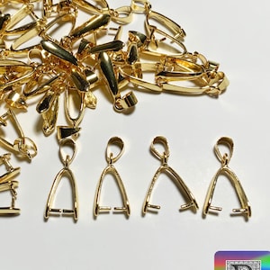 Może przedstawiać: Duża sterta złotych metalowych zawieszek do zawieszek, z czterema pojedynczymi zawieszkami pokazanymi w prawym dolnym rogu. Zawieszki mają kształt łzy z pętlą na górze. Obraz zawiera tekst "Bitsy Supply".