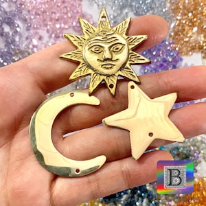Puede incluir: Tres abalorios de metal dorado en forma de sol, luna creciente y estrella de cinco puntas. El abalorio del sol tiene una cara con un diseño detallado. Los tres abalorios tienen dos agujeros para sujetarlos a joyas u otras manualidades.
