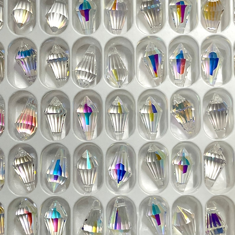 Peut inclure: Une vue rapproch&eacute;e d'une grille de 36 formes de larmes de cristal en verre transparent. Les cristaux sont dispos&eacute;s en rang&eacute;es et en colonnes, et ils sont tous de la m&ecirc;me taille et de la m&ecirc;me forme.