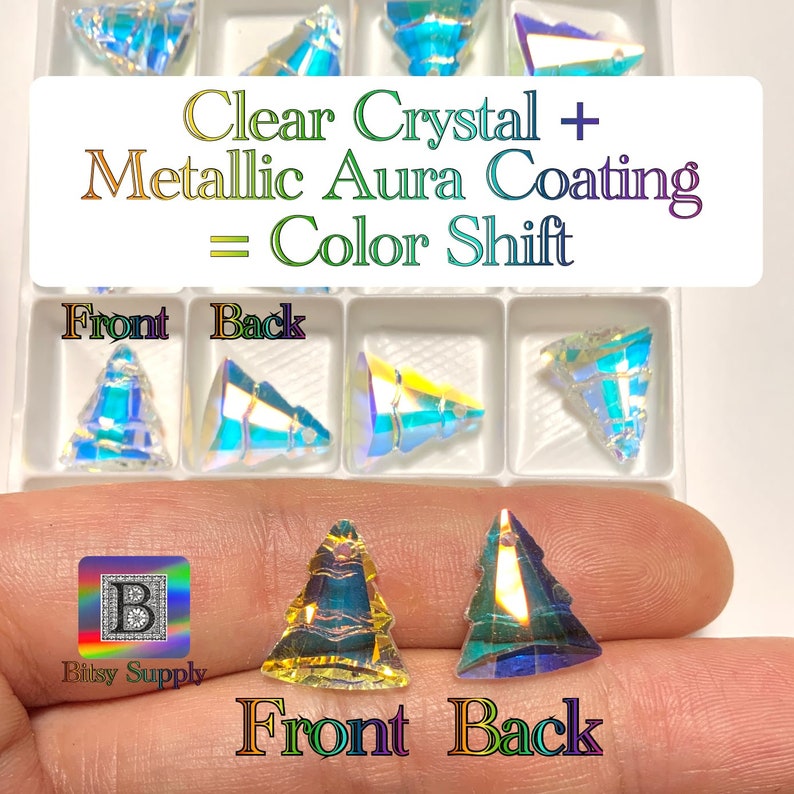 May include: Two clear crystal Christmas tree shaped ornaments with a metallic aura coating. The ornaments are shown from the front and back, showcasing the color shift effect. The text "Clear Crystal + Metallic Aura Coating = Color Shift" is displayed above the ornaments.