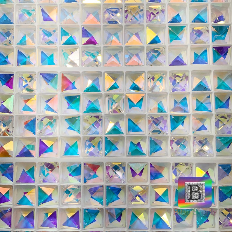K&ouml;nnte beinhalten: Eine Nahaufnahme einer Folie mit irisierenden, facettierten, quadratischen Kristallen. Die Kristalle sind in einem Raster angeordnet und in verschiedenen Farben erh&auml;ltlich, darunter Blau, Lila und Pink.