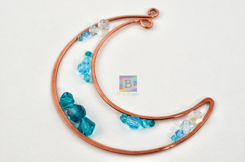 May include: Copper wire crescent moon shape with blue and clear glass beads. The moon has a loop at the top for hanging.