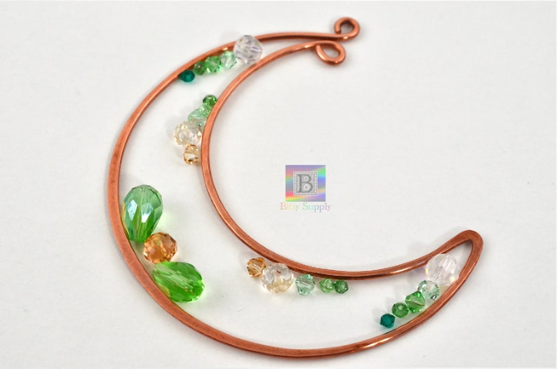 May include: Copper wire crescent moon shape with green, clear, and gold beads attached.