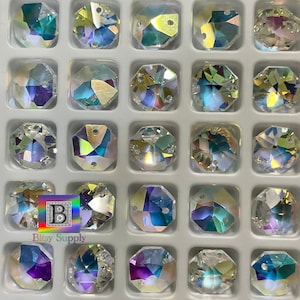 May include: A close-up view of 36 iridescent glass octagon-shaped beads with a hole in the center. The beads are arranged in a grid pattern in a white plastic container.