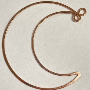 May include: A copper wire crescent moon shape with a loop at the top for hanging.