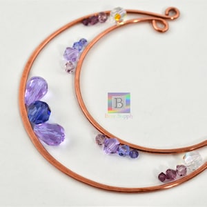 May include: Copper wire crescent moon shape with purple, blue, and clear glass beads attached.