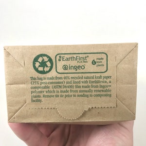 May include: A brown paper bag with a green EarthFirst&reg; logo and text that reads "This bag is made from 40% recycled natural kraft paper (25% post-consumer) and lined with EarthFirst&reg;, a compostable (ASTM D6400) film made from Ingeo&trade; polymer which is made from annually renewable plants. Remove tin tie prior to sending to composting facility."
