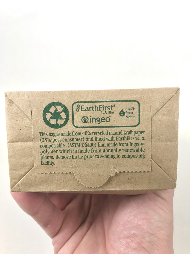 May include: A brown paper bag with a green EarthFirst&reg; logo and text that reads "This bag is made from 40% recycled natural kraft paper (25% post-consumer) and lined with EarthFirst&reg;, a compostable (ASTM D6400) film made from Ingeo&trade; polymer which is made from annually renewable plants. Remove tin tie prior to sending to composting facility."