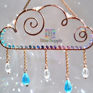May include: A copper wire cloud with a rainbow of crystals and dangling crystal drops. The cloud has a swirl design and the text "Bitsy Supply" is visible.