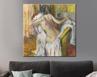 Peut inclure: Impression sur toile d'une œuvre de Degas représentant une figure nue dans un bain. L'œuvre utilise des couleurs pastel douces, avec le dos de la figure tourné et drapé de tissu blanc. L'arrière-plan présente des tons chauds de jaune et d'orange.