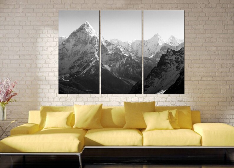 Pu&ograve; includere: Una fotografia in bianco e nero di una catena montuosa. Le montagne sono coperte di neve e il cielo &egrave; sereno. La foto &egrave; divisa in tre pannelli.