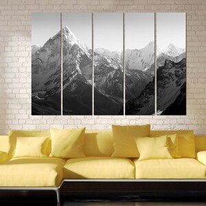 Pu&ograve; includere: Una fotografia in bianco e nero di una catena montuosa con cime innevate. L'immagine &egrave; divisa in cinque pannelli, creando una vista panoramica.