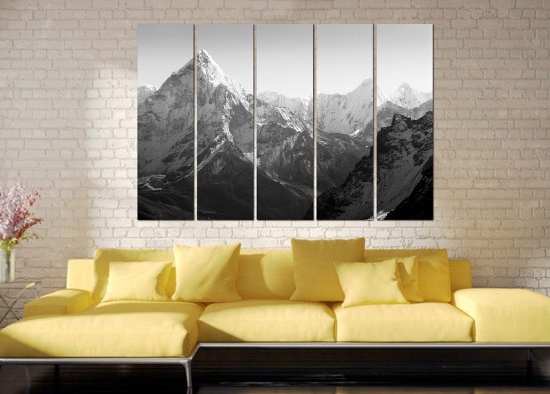 Pu&ograve; includere: Una fotografia in bianco e nero di una catena montuosa con cime innevate. L'immagine &egrave; divisa in cinque pannelli, creando una vista panoramica.