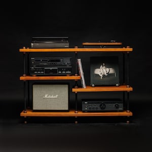 May include: Wooden audio rack with a turntable, amplifier, cassette deck, and a Marshall speaker. A vinyl record is visible on one shelf. The rack has a dark background. The measurements are in cm.