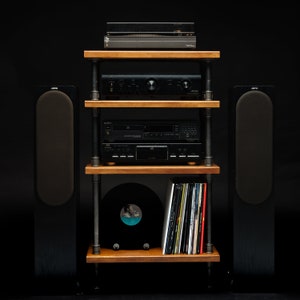 May include: A black stereo system with a turntable, amplifier, CD player, and two speakers on a wooden shelf unit with black metal pipes.