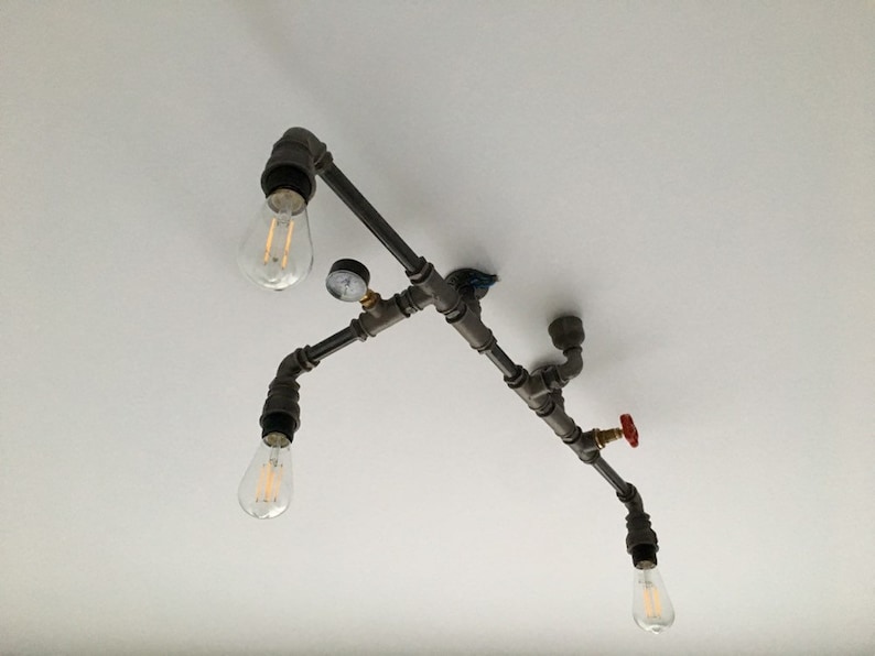 May include: A black metal pipe light fixture with four Edison bulbs and a red valve. The fixture is mounted to a white ceiling.