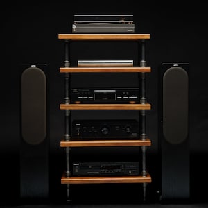 May include: A black stereo system with a turntable, CD player, amplifier, and two speakers on a wooden shelf unit with black metal legs.