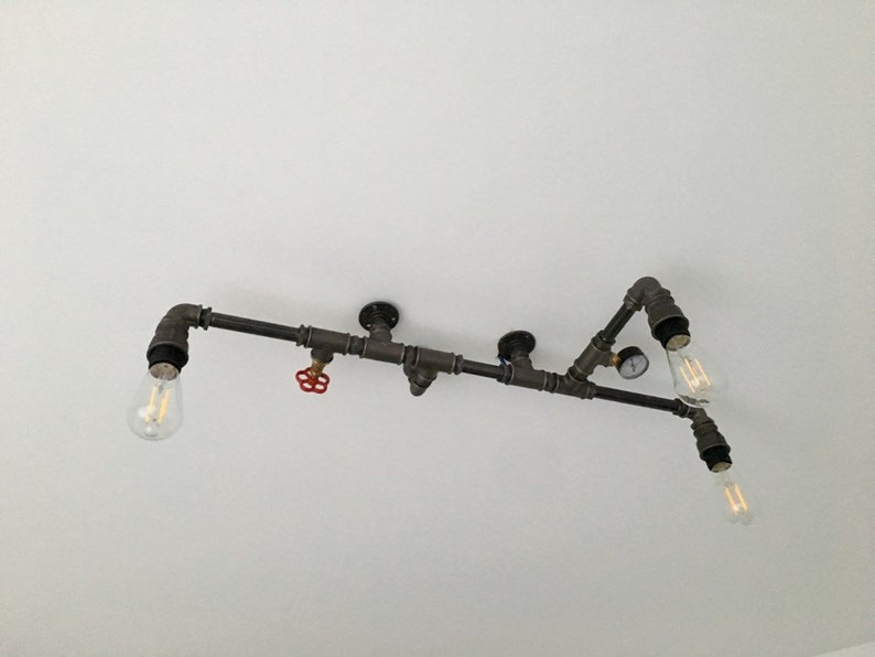 May include: A black metal pipe light fixture with four exposed light bulbs. The fixture has a red valve and a gauge.