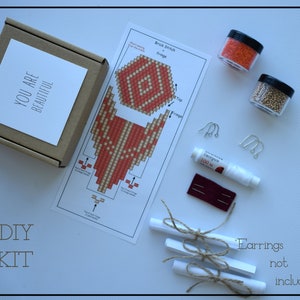 May include: A DIY kit for making earrings, featuring a brown box with "YOU ARE BEAUTIFUL" printed on it, a diagram, beads, thread, needles, and earring hooks. The words "DIY KIT" are printed at the bottom.