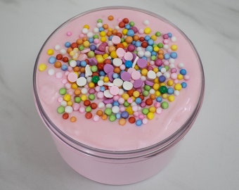May include: Pink slime with colourful sprinkles in a clear plastic container.