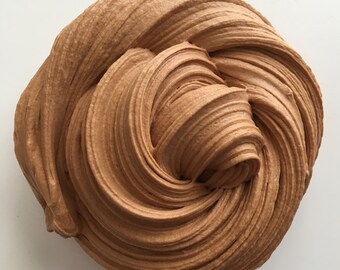 May include: A close-up of brown slime with a swirl pattern. The slime is soft and smooth, and it looks like it would be fun to play with.