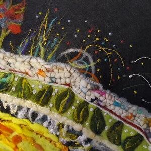 Op de afbeelding: Een close-up van een kleurrijk, getextureerd kunstwerk met een groene, witte en rode rand op een witte, pluche achtergrond. Het kunstwerk is versierd met kleine, kleurrijke stippen en een paar witte lijnen.
