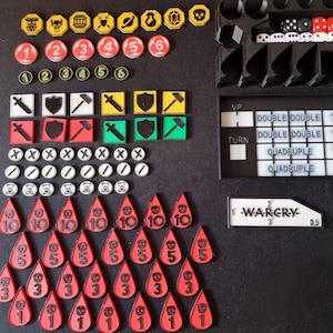 Op de afbeelding: Een set spelstukken voor een bordspel. De stukken zijn gemaakt van plastic en zijn in verschillende kleuren, waaronder rood, zwart, wit en geel. De stukken omvatten dobbelstenen, tokens en kaarten. Het spel heet "Warcry".