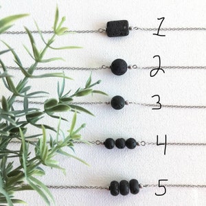 Minimalistiskt boho halsband eller choker med svart lavasten. Ovaxade lavapärlor på kedja i rostfritt stål. För användning med eteriska oljor.