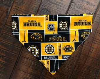 May include: A black and yellow dog bandana with the Boston Bruins logo and the text "Boston Bruins" repeated throughout the design.