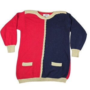 May include: A two-tone sweater in red and navy blue, with gold trim and accents. The sweater features a split design, with one side red and the other navy blue. The sleeves and hem have gold trim, and there are two small pockets.