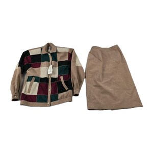 May include: A two-piece outfit featuring a patchwork jacket and a skirt. The jacket has a button-up front, pockets, and a mix of colors including beige, black, burgundy, and green. The skirt is a solid beige color.