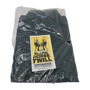 May include: A dark green work shirt, sealed in a clear plastic bag. A yellow and white label with the text "WORK HORSE TWILL" and two horse illustrations is visible. The shirt is from Toppmaster.
