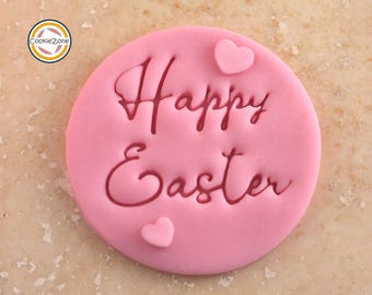 May include: Pink fondant cookie decorated with red icing that says "Happy Easter" and two pink fondant hearts.