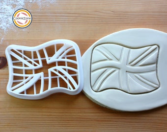May include: A white plastic cookie cutter shaped like the Union Jack flag of the United Kingdom. The cutter is shown next to a piece of white fondant with the flag design embossed into it.