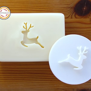 Può includere: Tagliabiscotti in plastica bianca a forma di renna. Il tagliabiscotti a sinistra è un design a spazio negativo, mentre il tagliabiscotti a destra è un design solido.