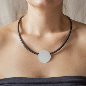 Handmade modern necklace made of silver and caoutchouc. Unique geometrical design